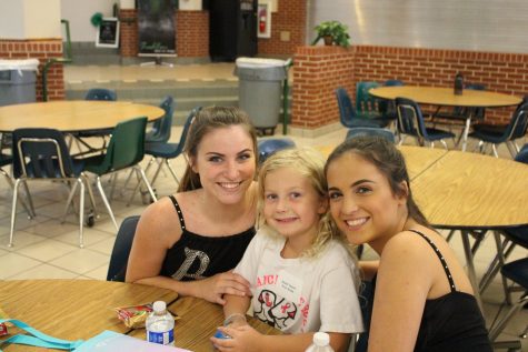 Ryleigh Malloy (12) and Delaney Malloy (10) pose for a picture with a junior belle at snack time. 