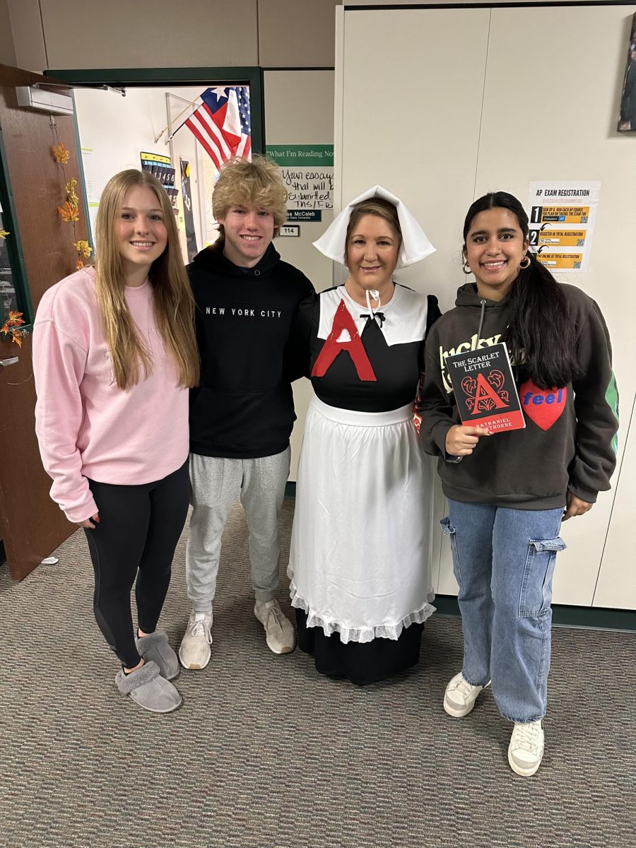 AP Lang teacher, Ms. McCaleb, pictured with some of her students, dressed as Hester Prynne for Halloween. Her students were reading The Scarlet Letter for their first American Literature period, Puritanism.