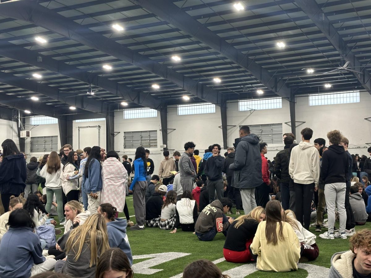 Students gather in the indoor practice facility after the main building was evacuated. 