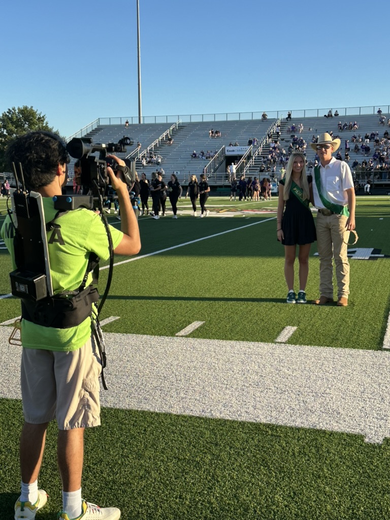 A CSMI intern films the 2024 homecoming king and queen during a pre-game ceremony last school year.